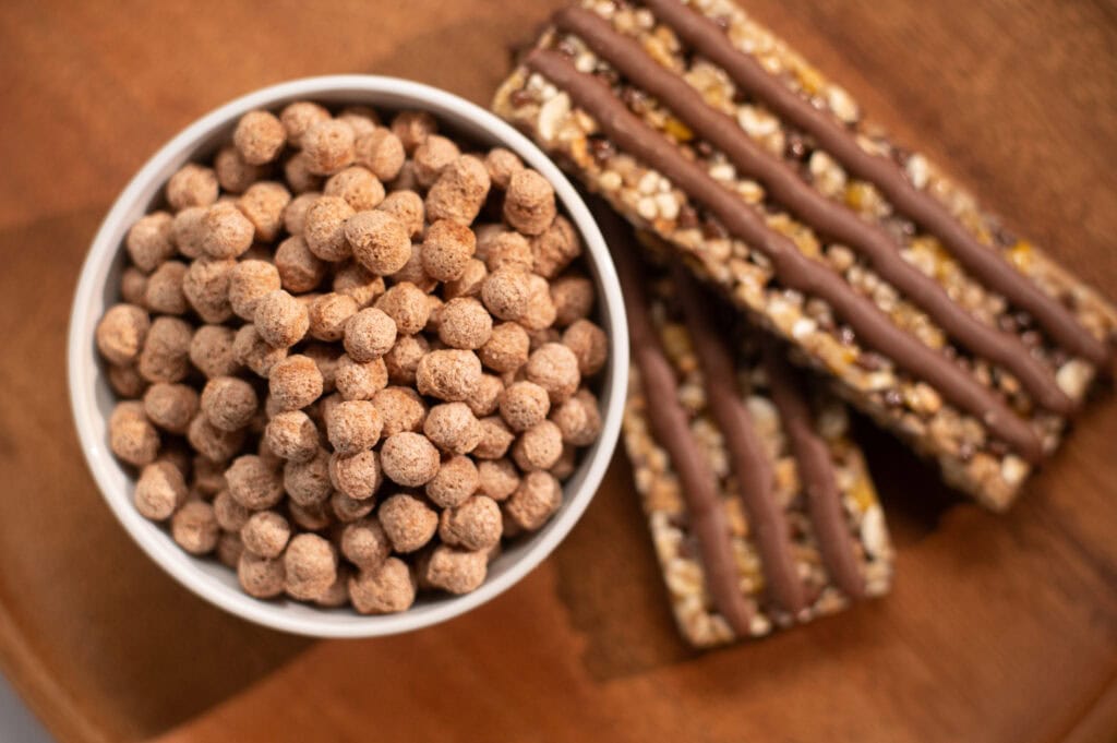 eine Schüssel mit Protein Balls mit PurusPro® Gerstenprotein von ClonBio und Müsliriegel mit Proteinextrudaten mit PurusPro